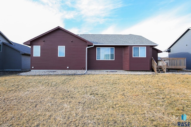 rear view of house with a wooden deck and a yard