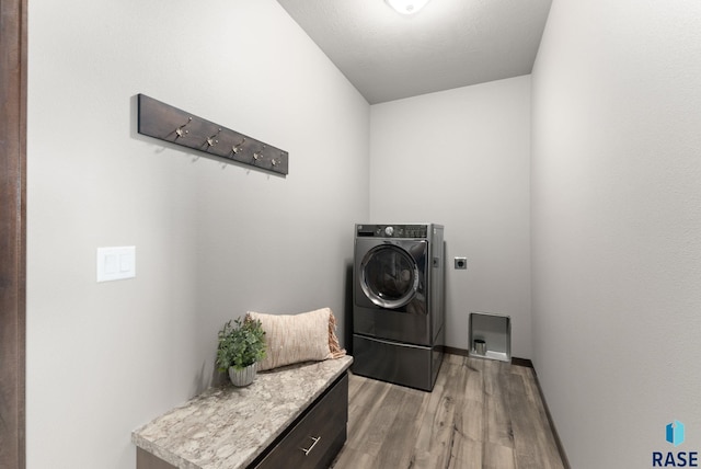 clothes washing area with light wood-type flooring and washer / clothes dryer