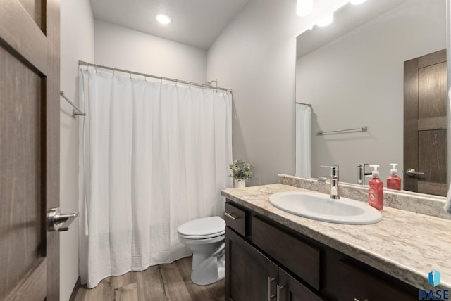 bathroom with vanity, toilet, and wood-type flooring