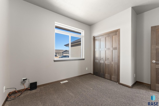 unfurnished bedroom featuring carpet and a closet