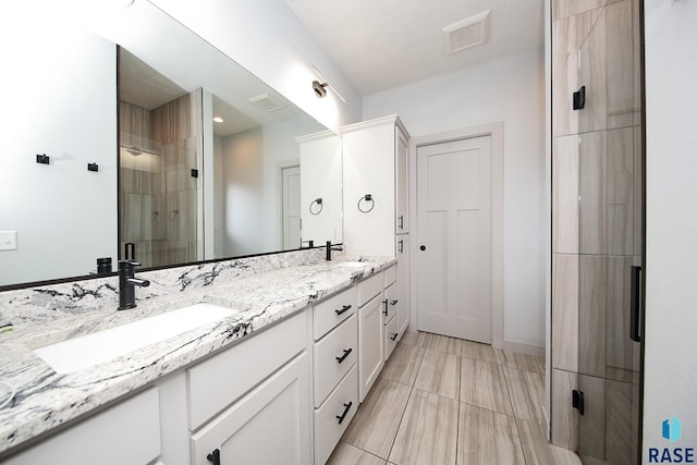 bathroom featuring vanity and an enclosed shower