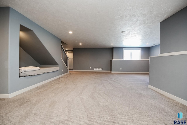 unfurnished living room featuring light colored carpet and a textured ceiling