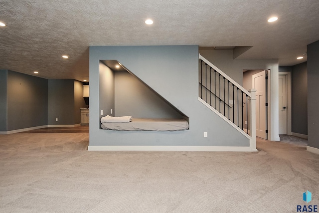 unfurnished living room with light carpet and a textured ceiling