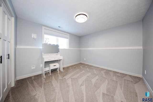 unfurnished office with light colored carpet and a textured ceiling