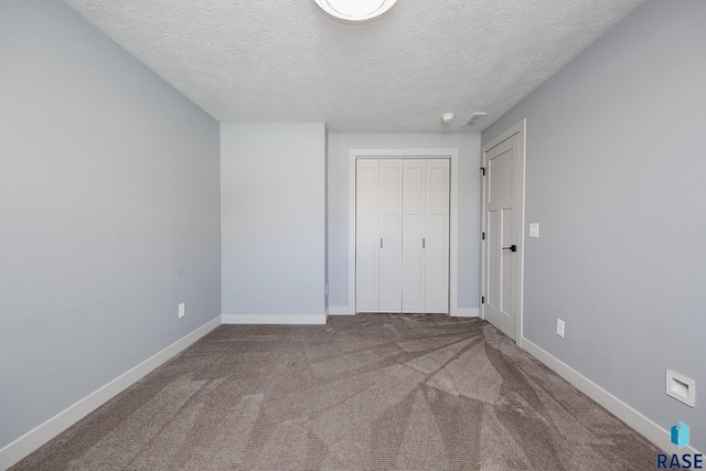 unfurnished bedroom with a closet, carpet, and a textured ceiling