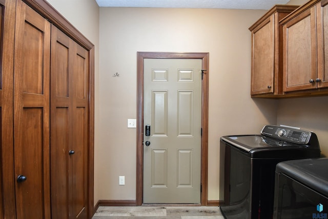 washroom with cabinets, independent washer and dryer, and light wood-type flooring