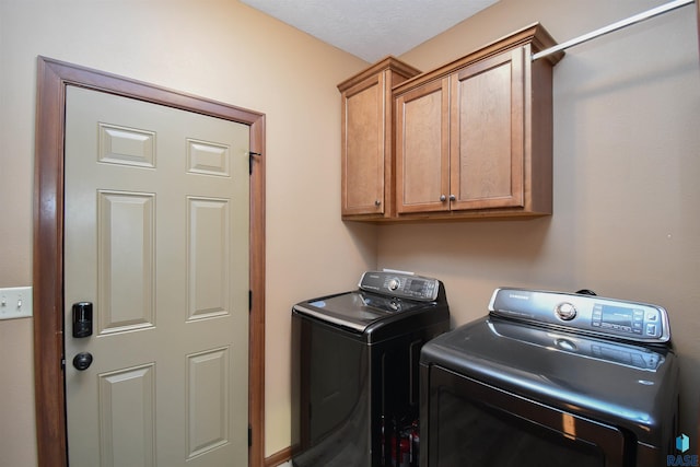 laundry room featuring washer and dryer and cabinets