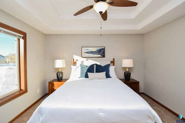 bedroom featuring a raised ceiling, ceiling fan, and carpet floors