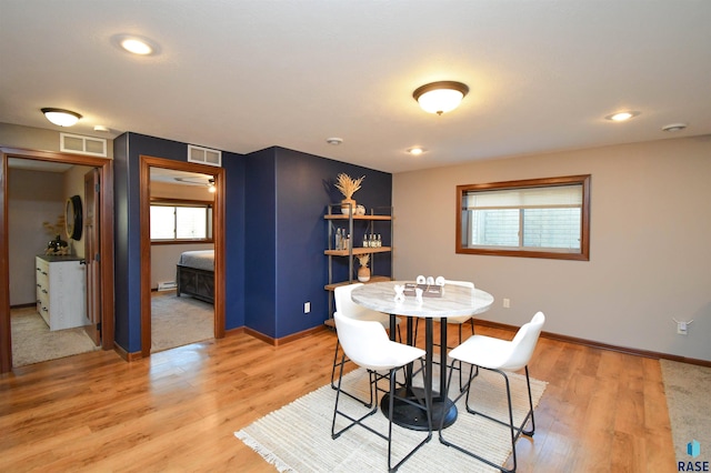 dining area featuring a healthy amount of sunlight, a baseboard radiator, and hardwood / wood-style flooring