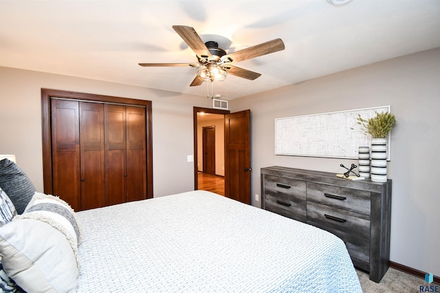 carpeted bedroom featuring a closet and ceiling fan