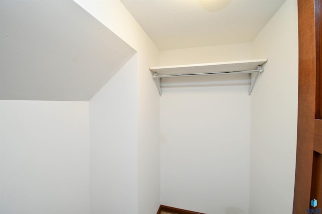 walk in closet with lofted ceiling