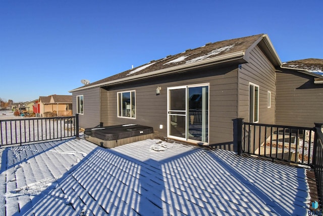 snow covered deck with a covered hot tub