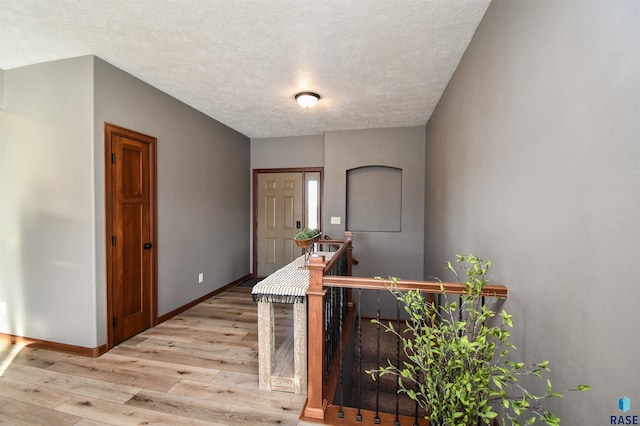 entryway featuring light wood-type flooring and a textured ceiling