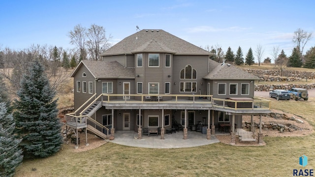 rear view of property featuring a patio, a lawn, and a wooden deck