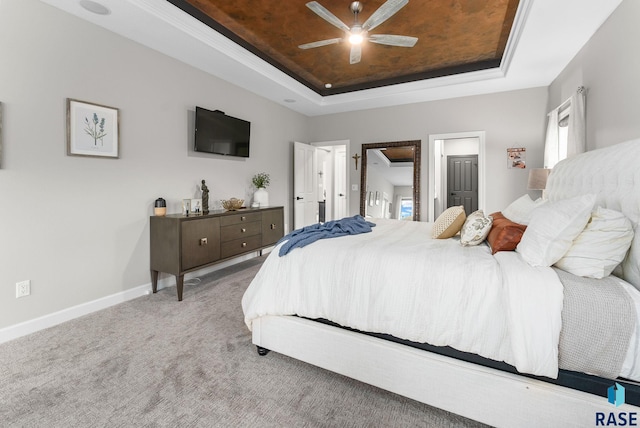 bedroom with ceiling fan, a raised ceiling, and carpet