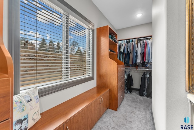 walk in closet featuring light carpet