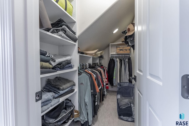 walk in closet featuring light carpet and vaulted ceiling