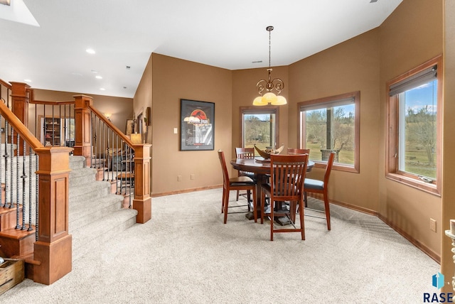 dining area featuring light colored carpet and a chandelier