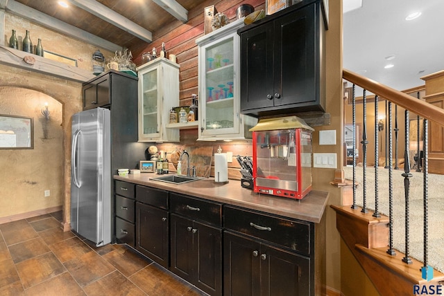 kitchen with wooden ceiling, beamed ceiling, stainless steel fridge, sink, and tasteful backsplash