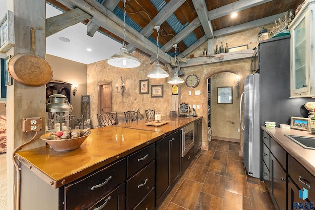 kitchen with hanging light fixtures, high vaulted ceiling, beamed ceiling, and stainless steel appliances