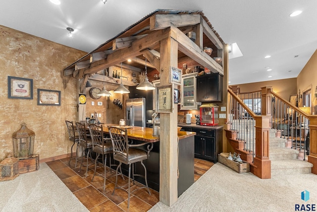 bar with butcher block countertops and stainless steel refrigerator with ice dispenser