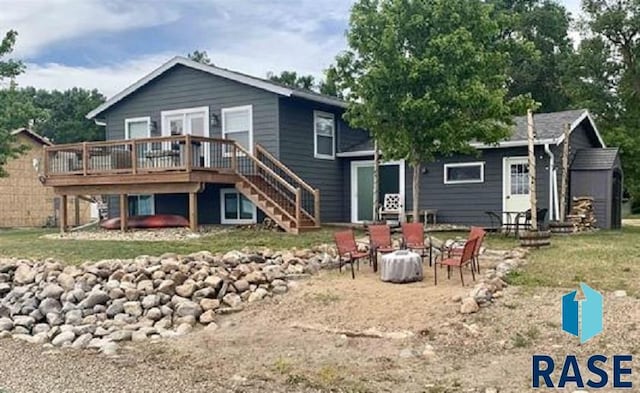 back of property with a fire pit and a wooden deck