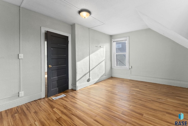 additional living space featuring vaulted ceiling and wood-type flooring