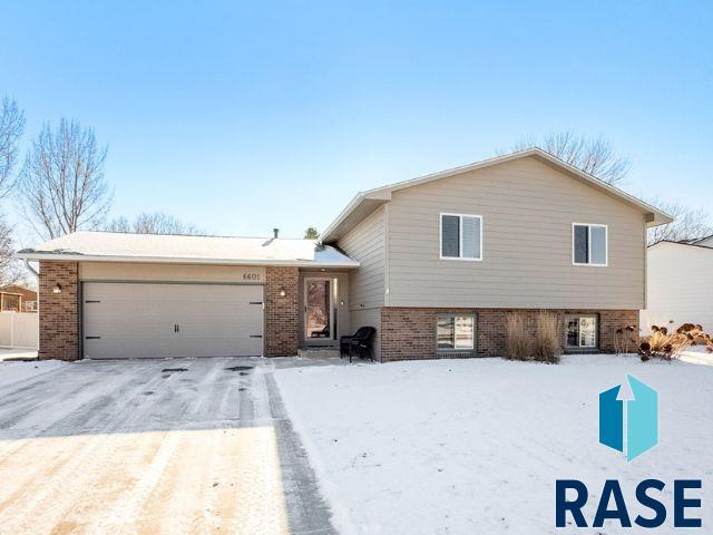 split level home featuring brick siding and an attached garage