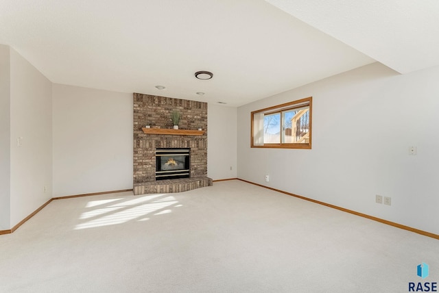 unfurnished living room featuring a fireplace, carpet flooring, and baseboards