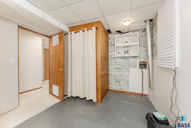 interior space with baseboards, visible vents, and a drop ceiling