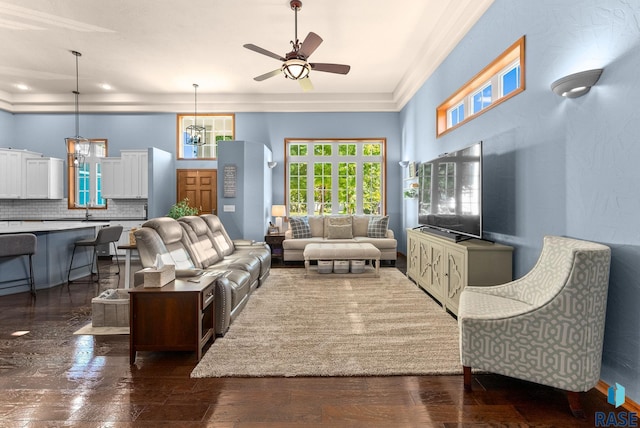 living room featuring ceiling fan, crown molding, and sink