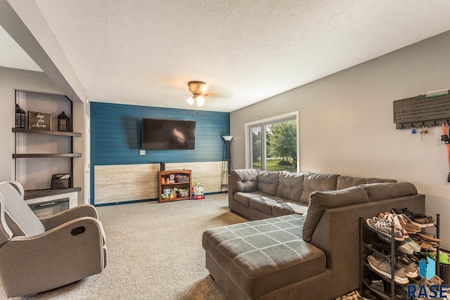 carpeted living room with a textured ceiling and ceiling fan