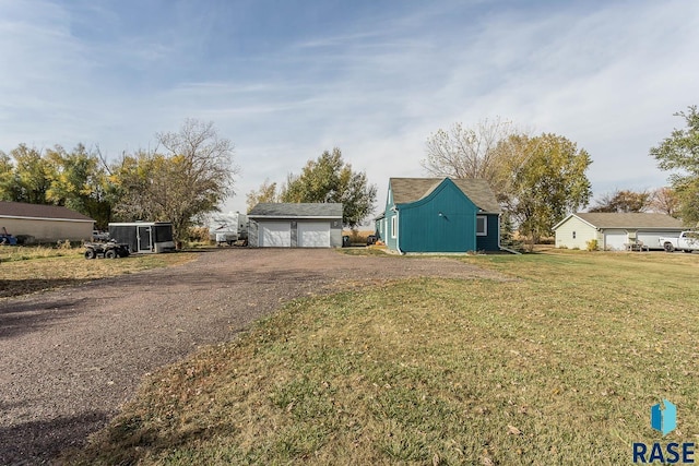 exterior space featuring a garage, an outbuilding, and a lawn