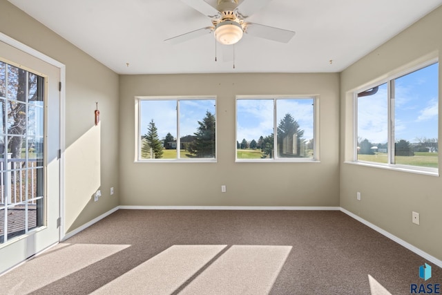 unfurnished sunroom with ceiling fan