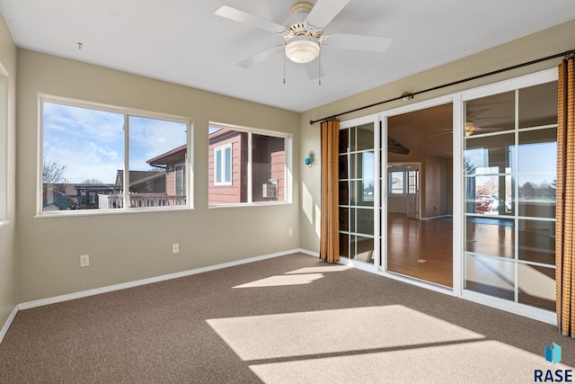 spare room with carpet flooring, ceiling fan, and a healthy amount of sunlight