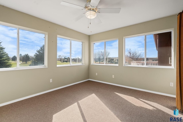 carpeted spare room featuring ceiling fan