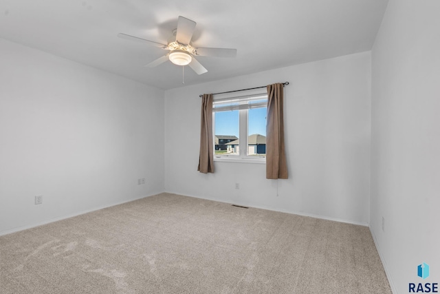 unfurnished room with ceiling fan and carpet