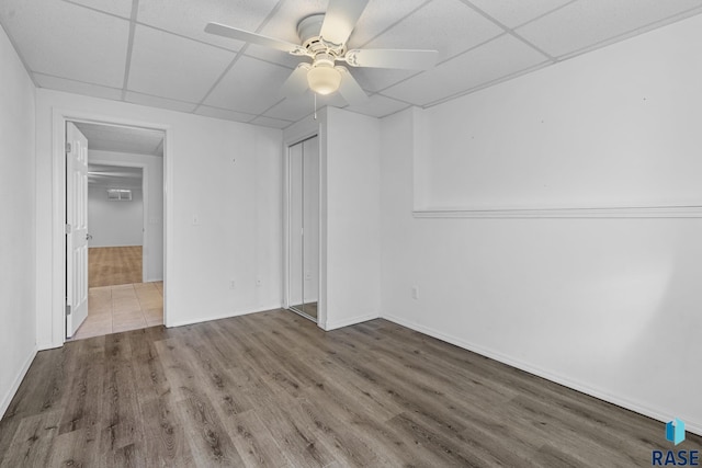 spare room featuring a paneled ceiling, wood-type flooring, and ceiling fan