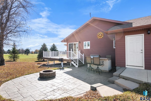 view of patio with a deck, a fire pit, and exterior bar