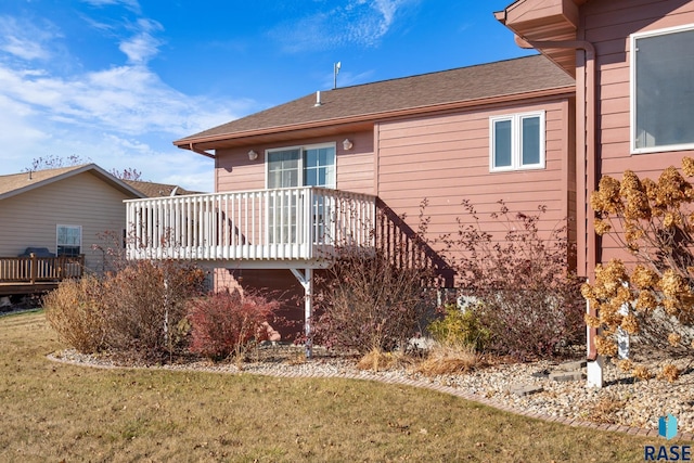 view of home's exterior with a deck and a yard