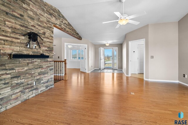 unfurnished living room with light hardwood / wood-style floors, ceiling fan, and lofted ceiling