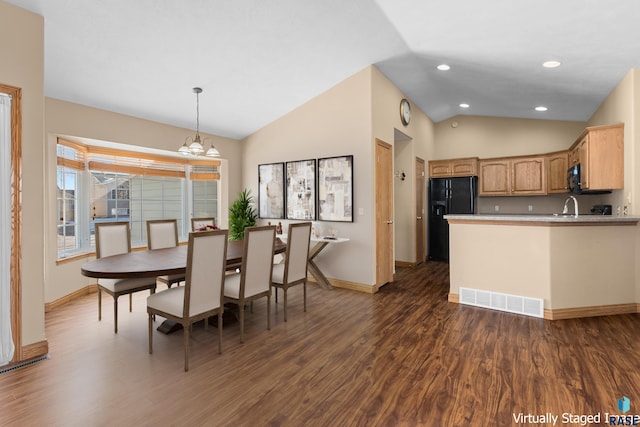 dining room with a notable chandelier, dark wood-type flooring, high vaulted ceiling, and sink