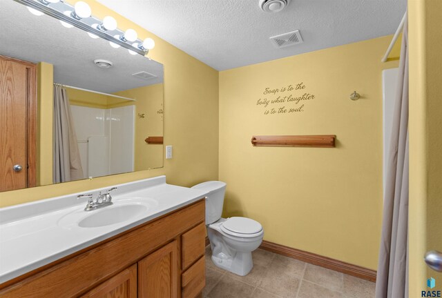 bathroom with a textured ceiling, a shower with shower curtain, vanity, and toilet