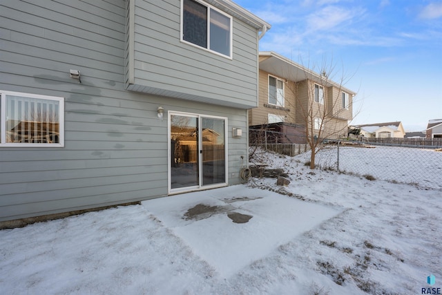 view of snow covered back of property