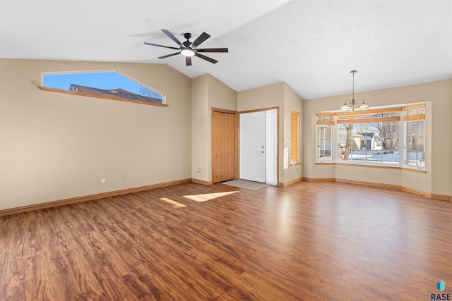 unfurnished living room featuring ceiling fan with notable chandelier, hardwood / wood-style flooring, and vaulted ceiling