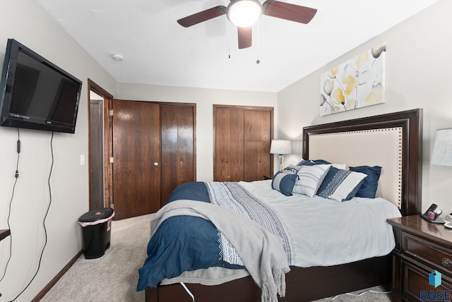 bedroom featuring multiple closets, ceiling fan, and light colored carpet