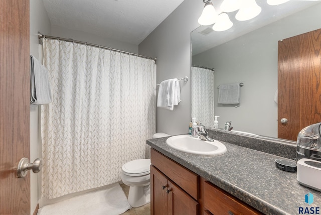 bathroom featuring toilet, tile patterned flooring, a textured ceiling, and vanity