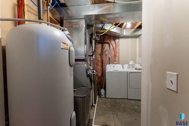 clothes washing area featuring separate washer and dryer and electric water heater