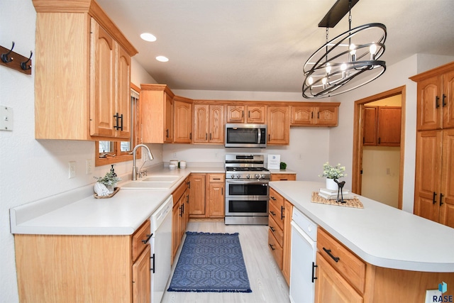 kitchen with a chandelier, appliances with stainless steel finishes, hanging light fixtures, light hardwood / wood-style floors, and sink