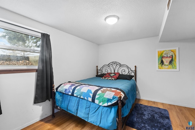 bedroom featuring a textured ceiling and wood-type flooring